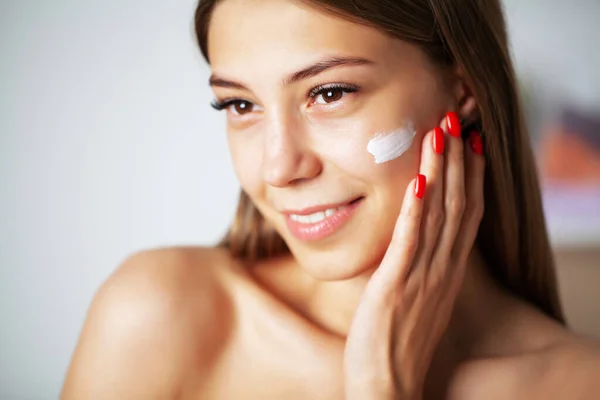 Mooi meisje doet gezichtsverzorging procedure in de badkamer — Stockfoto