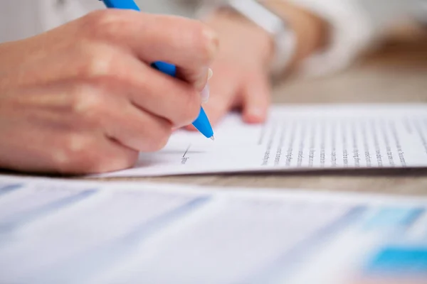 Business woman signs a contract in the office at the table — Stock Photo, Image