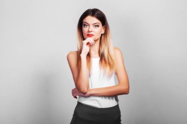 Gri arka planda fotokopi aletiyle duran düşünceli kızın portresi.