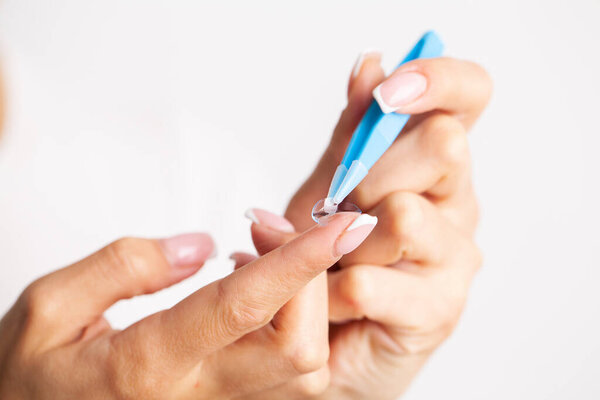 Woman removes contact lenses from a container with liquid
