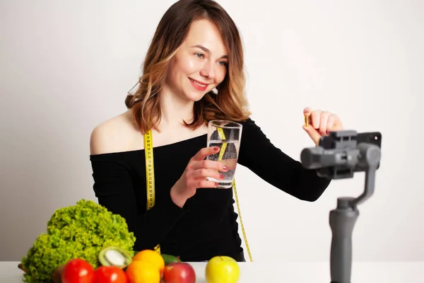 Una joven en lightroom escribe un blog sobre la pérdida de peso y la alimentación saludable — Foto de Stock