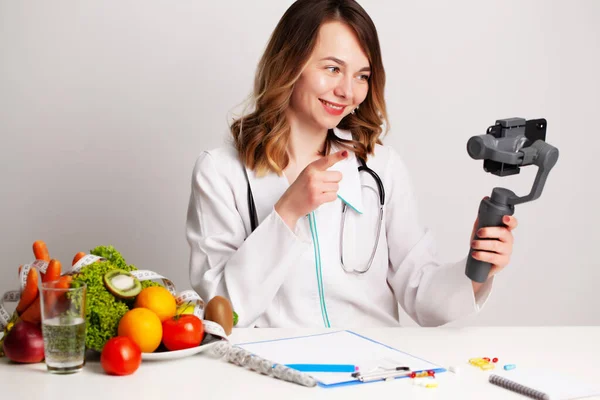 Un joven dietista en una sala de consulta escribe un blog sobre la pérdida de peso y la alimentación saludable — Foto de Stock