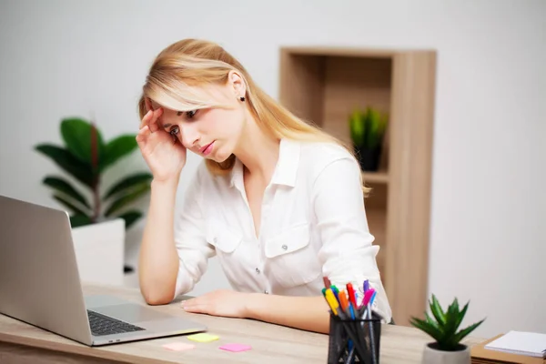 Zmęczona młoda bizneswoman wyczerpana w miejscu pracy w swoim biurze — Zdjęcie stockowe