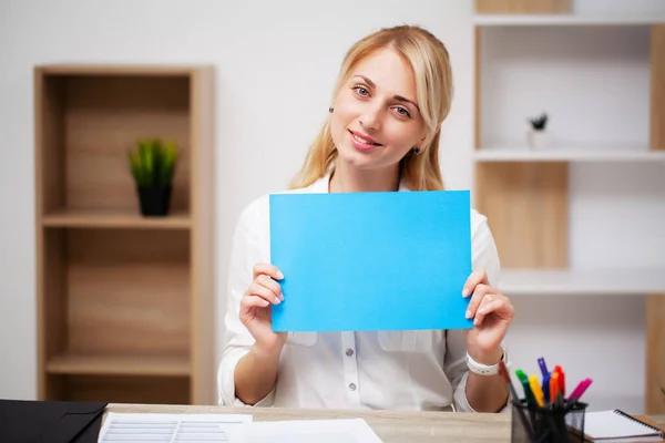Obchodní koncepce, žena držící prázdný list papíru s místem pro text na pracovišti — Stock fotografie