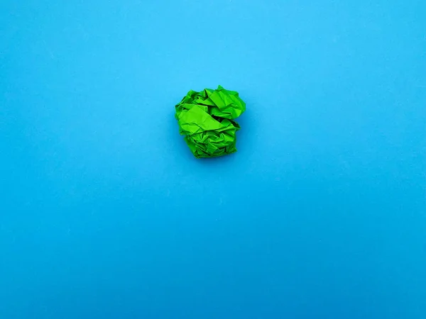 Úspěšný nápad koncept, zelený zmačkaný list papíru na modrém pozadí — Stock fotografie