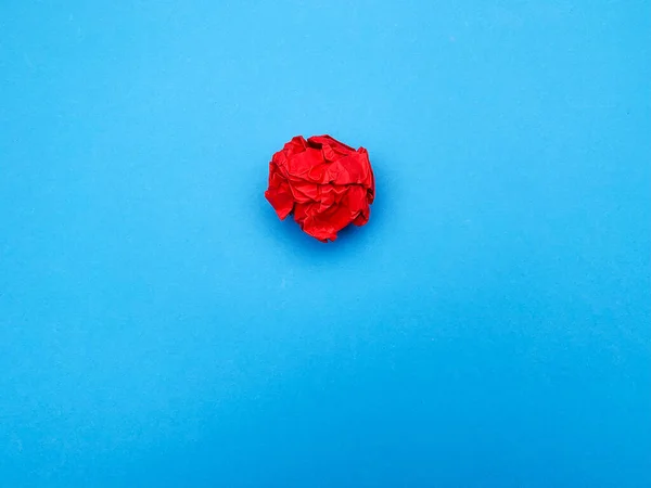 Conceito de ideia de sucesso, folha de papel vermelha amassada no fundo azul — Fotografia de Stock