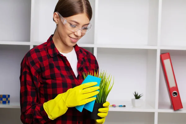 Employee of a cleaning company in overalls and yellow gloves cleans the office — Stock Photo, Image