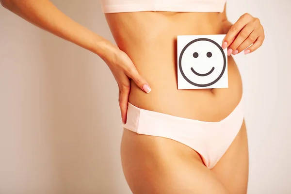 Salud estomacal y buenos conceptos de digestión, primer plano de la mujer sana con hermoso ajuste delgado cuerpo celebración tarjeta con sonrisa feliz en las manos . — Foto de Stock