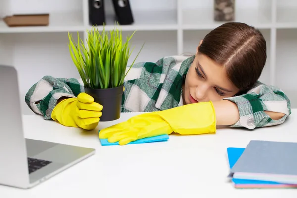 Pracownik firmy sprzątającej w kombinezonach i żółtych rękawiczkach czyści biuro — Zdjęcie stockowe