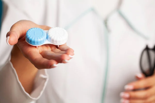 Médica feminina fechar segurando um recipiente com lentes ópticas — Fotografia de Stock