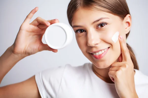 Cura della pelle, giovane donna con bellezza viso uso crema per la pelle del viso — Foto Stock