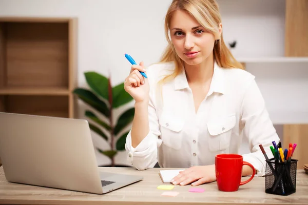 Ділова жінка працює на ноутбуці в своєму офісі — стокове фото