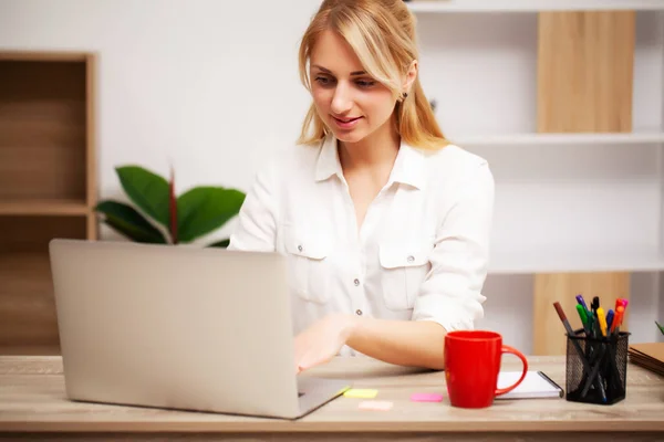 Affärskvinna som arbetar på laptop på sitt kontor — Stockfoto