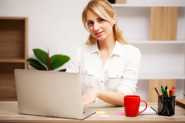 Affärskvinna som arbetar på laptop på sitt kontor — Stockfoto