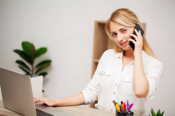 Affärskvinna pratar i telefon på sitt kontor — Stockfoto