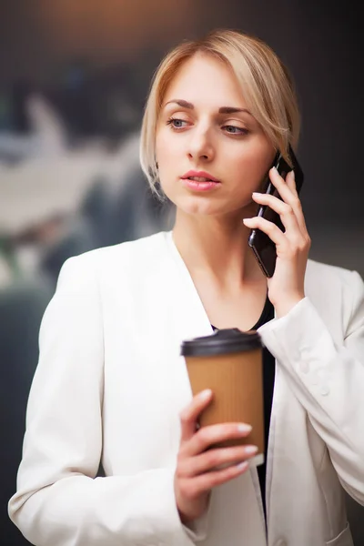 Affärskvinna chef dricka kaffe från en pappersmugg på företagets kontor — Stockfoto