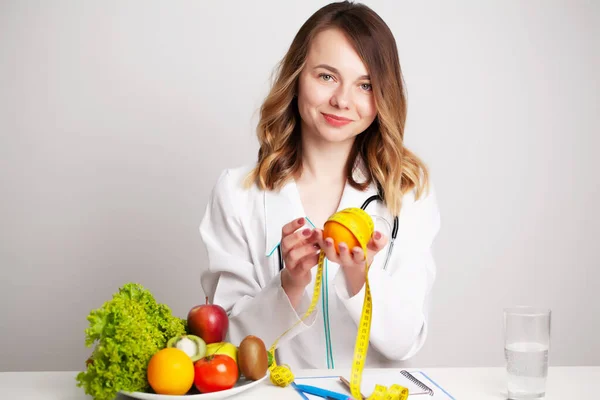 Nutricionista hace un plan de dieta para una nutrición adecuada para el paciente en su consultorio — Foto de Stock