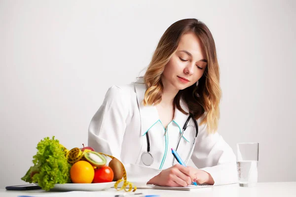 Nutricionista hace un plan de dieta para una nutrición adecuada para el paciente en su consultorio —  Fotos de Stock