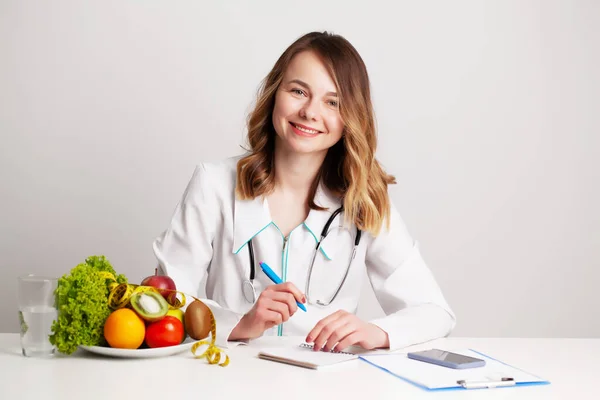 Nutricionista hace un plan de dieta para una nutrición adecuada para el paciente en su consultorio — Foto de Stock