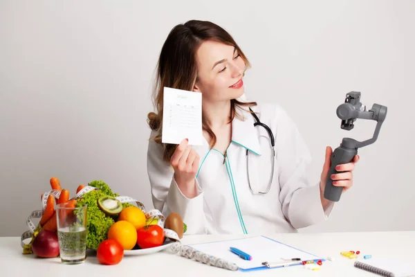 Nutricionista graba un video blog sobre alimentación saludable en un teléfono móvil — Foto de Stock
