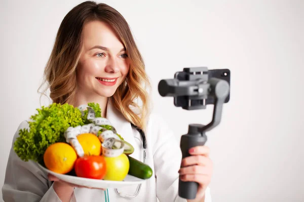 Nutricionista graba un video blog sobre alimentación saludable en un teléfono móvil — Foto de Stock