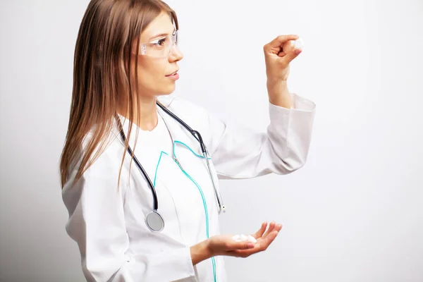 Jovem médica segurando uma pílula de vitaminas — Fotografia de Stock