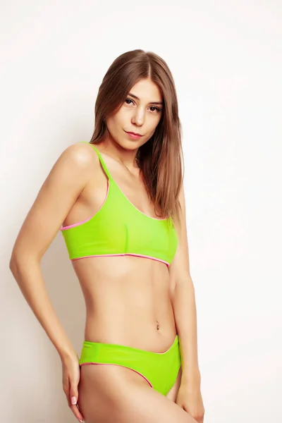 Schöne Frau in einem hellgrünen Badeanzug und einer schönen Körperform — Stockfoto