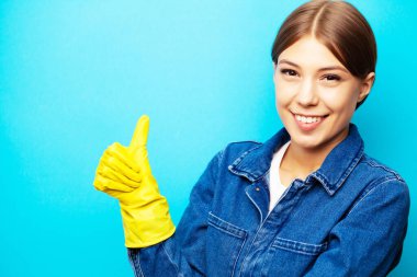 Özel üniformalı ve sarı eldivenli gülümseyen temizlikçi.