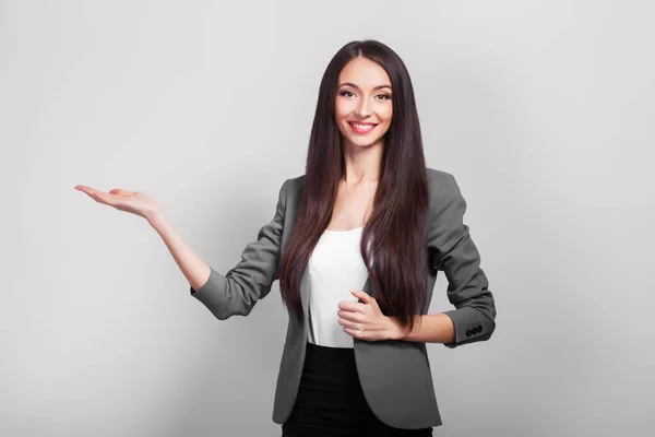 Überraschte Geschäftsfrau zeigt ihr Produkt mit der Hand. — Stockfoto