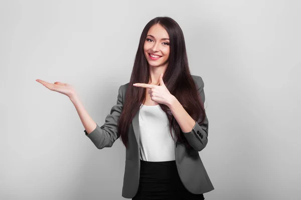 Surprised businesswoman dshows your product with her hand. — Stock Photo, Image