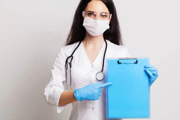 Médica segurando uma folha de papel em branco com espaço para texto — Fotografia de Stock