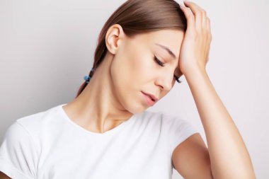 Baş ağrısı, yorgun genç kadın dayanılmaz bir baş ağrısı çekiyor.