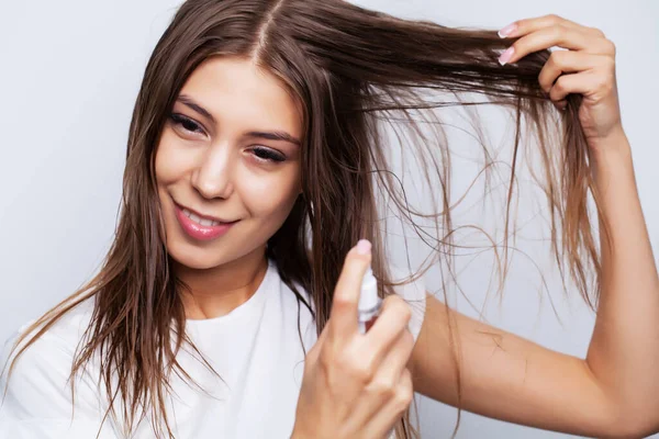 Junge schöne Frau wendet Conditioner auf strapaziertes Haar zur Wiederherstellung und Pflege der Haare an — Stockfoto