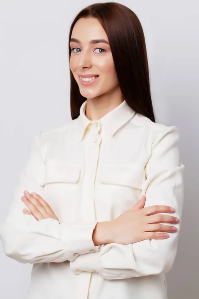 Portret van een mooie zakenvrouw met een mooie glimlach op een grijze achtergrond — Stockfoto
