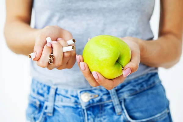 Dejar de fumar, primer plano de la mujer sosteniendo cigarrillos rotos y manzana verde —  Fotos de Stock