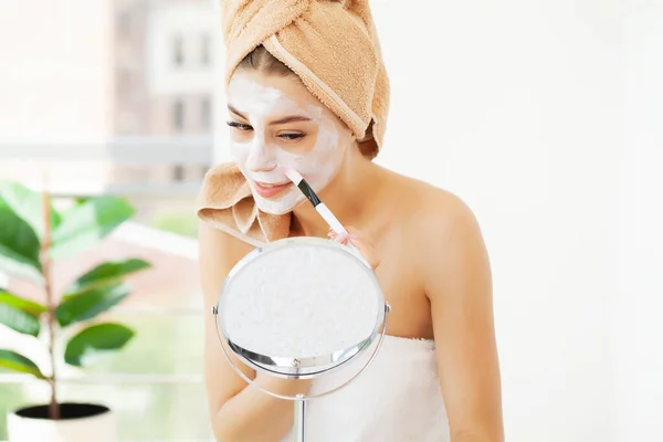 Cuidado de la piel, mujer joven con hermosa piel facial aplicando máscara en la cara — Foto de Stock