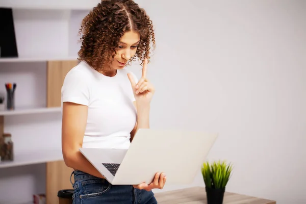 Hermosa mujer de negocios con una sonrisa en su cara trabajando en la oficina en un ordenador portátil —  Fotos de Stock