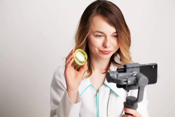 Young nutritionist records a video on the phone — Stock Photo, Image