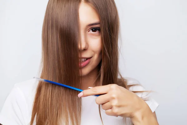 年轻女人用梳子梳理她美丽的头发 — 图库照片