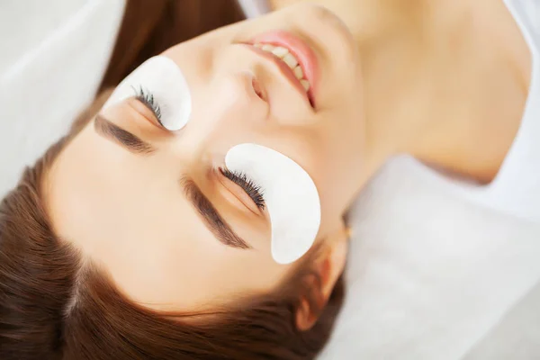 Portrait of a beautiful woman making herself new eyelashes in a beauty studio — Stock Photo, Image