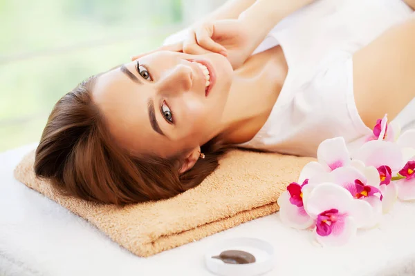 Jovem com belo rosto na massagem facial no estúdio de beleza — Fotografia de Stock