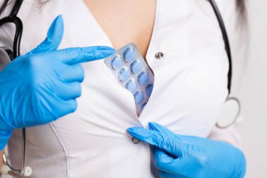 Doktorun elinde erkeklerin cinsel sağlığı için bir hap var.