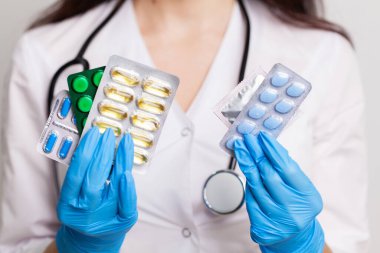 Doktorun elinde erkeklerin cinsel sağlığı için bir hap var.