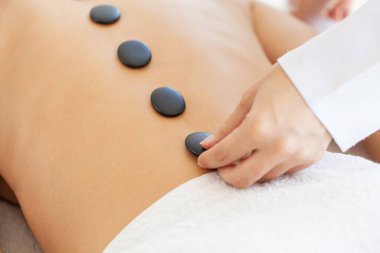 Spa taşı masajı, kaplıcada masaj yaptıran güzel bir kadın..