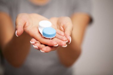 Görme düzeltmesi için konteynır konteynırı tutan kadın