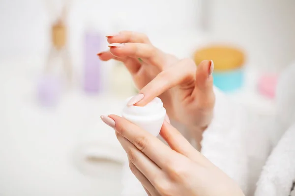 Close up of woman holding moisturizer for facial skin care — Stock Photo, Image