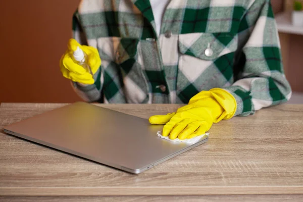 Женщина стирает ноутбук из пыли в офисе за столом — стоковое фото