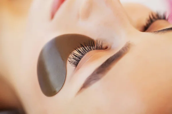 Pielęgnacja skóry pod oczami, plastry są nakładane na oczy młodych kobiet — Zdjęcie stockowe
