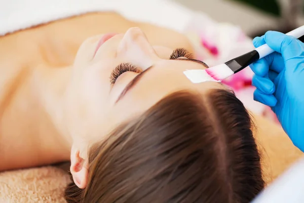 Kobieta stosuje maskę spa do nawilżania i pielęgnacji skóry w studiu kosmetycznym — Zdjęcie stockowe