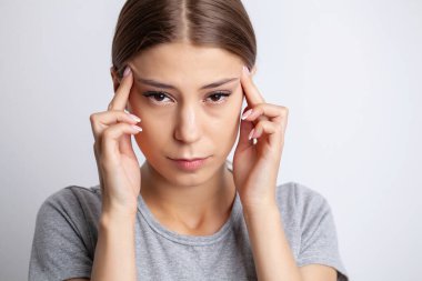 Genç bir kadının şiddetli bir baş ağrısı var.